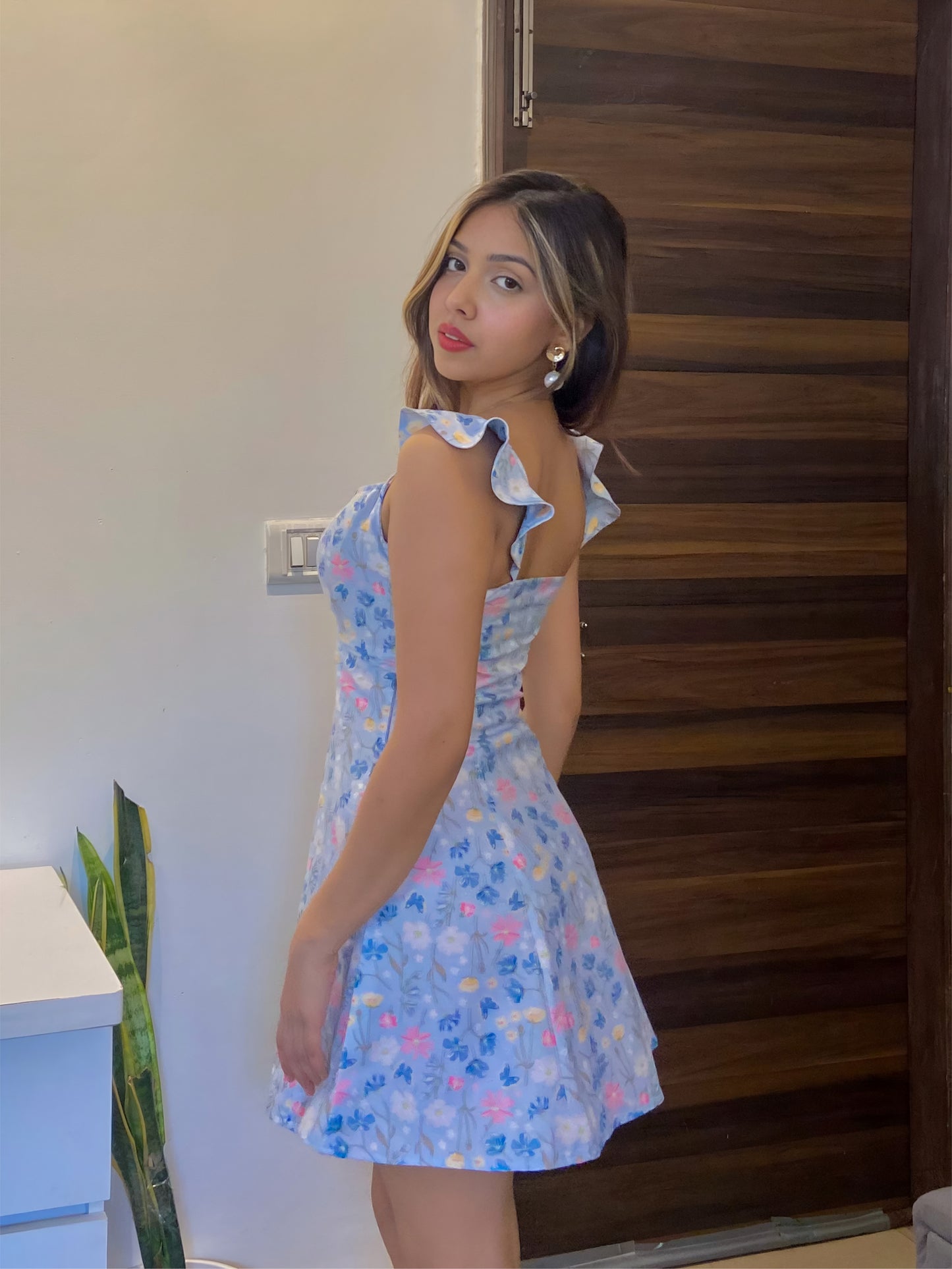 A short blue Summer floral dress, a side pose