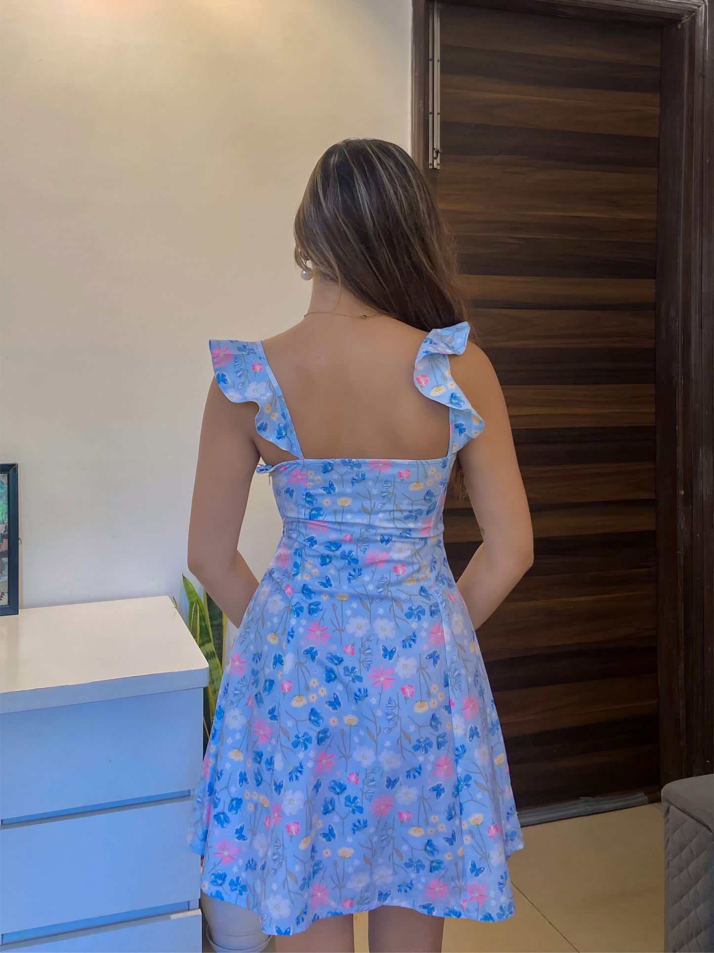 A short blue Summer floral dress, a back pose