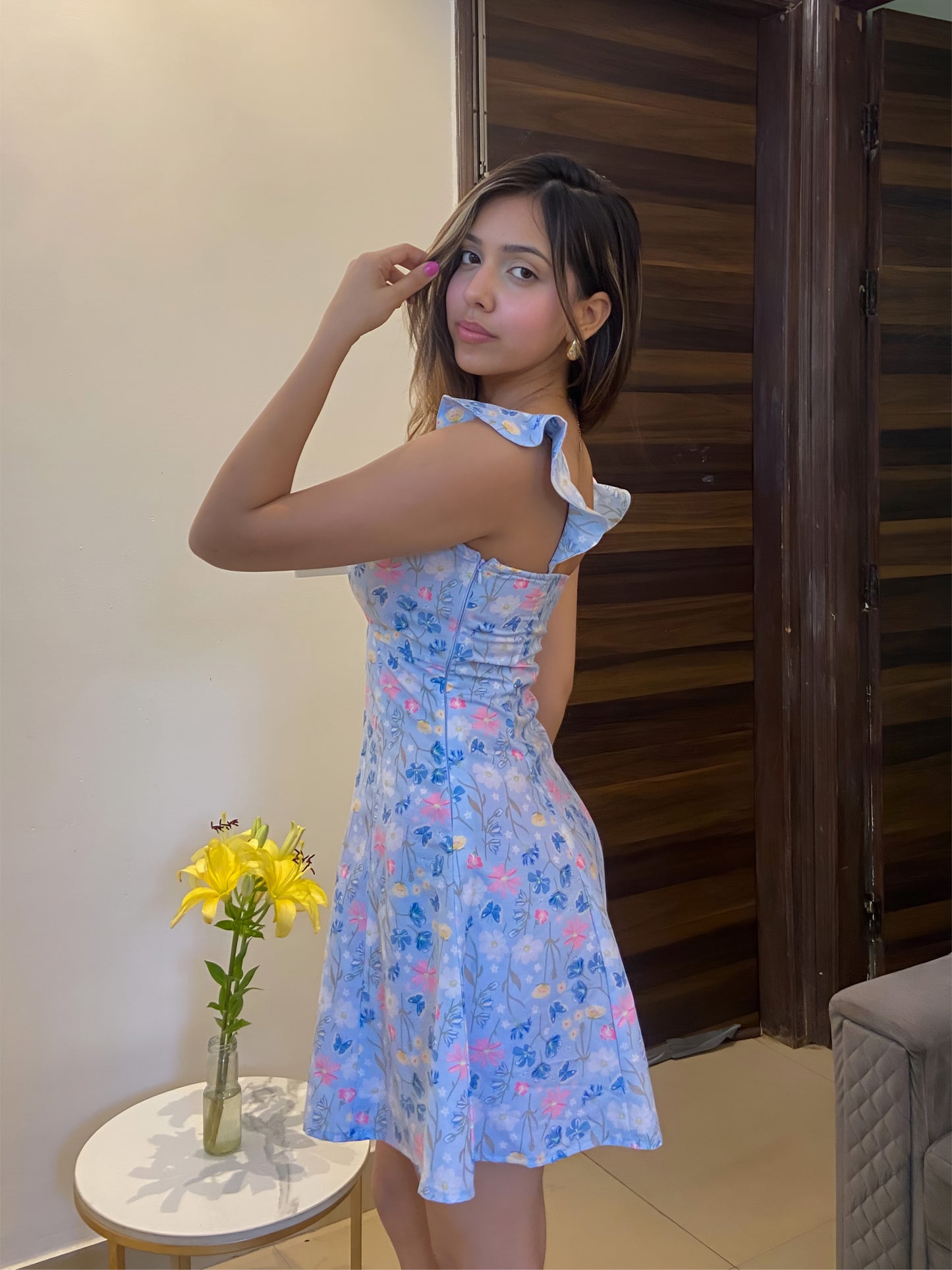 A short blue Summer floral dress, a side pose
