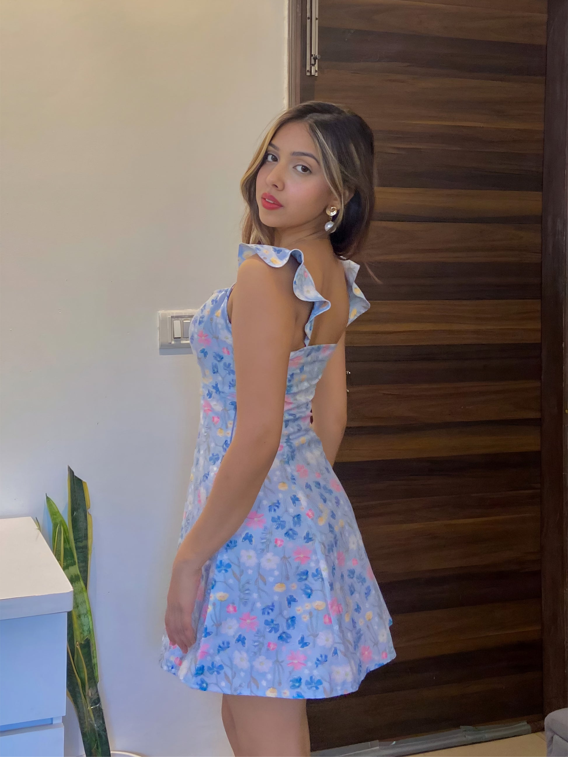 A short blue Summer floral dress, a side pose