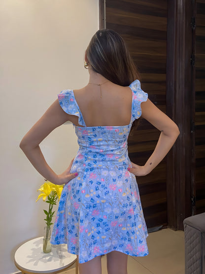 A short blue Summer floral dress, a back pose